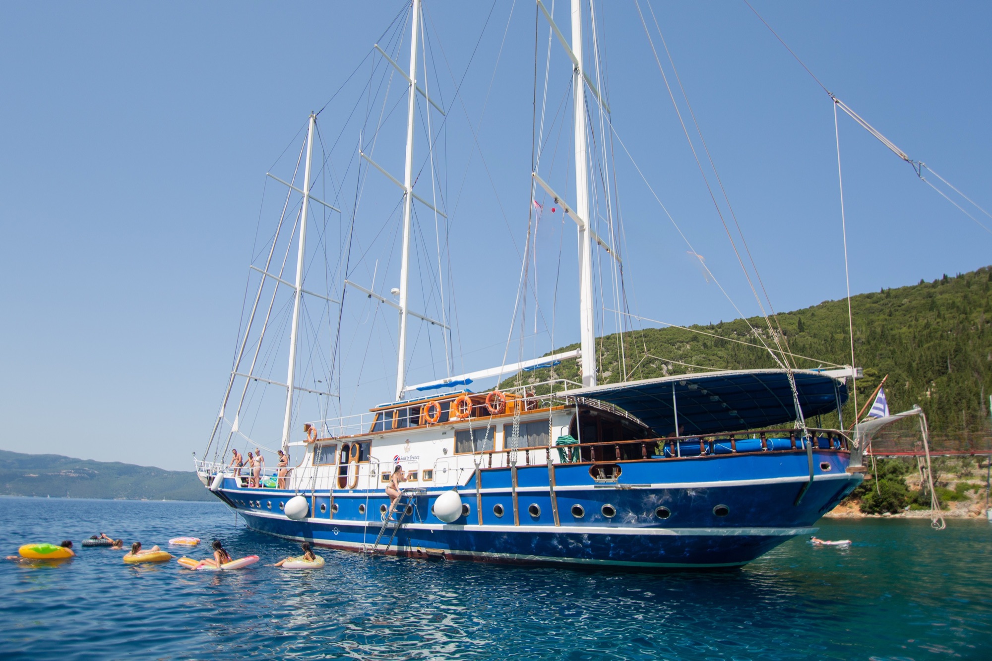Sail Greece gulet anchored in a bay, guests swimming alongside